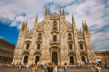 Duomo square crowded by people in sunny day Italy, Milan. Duomo di Milano cathedral with spires and crowd of people are walking on Piazza del Duomo square. Christianity, dome