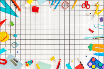School supplies on paper checked background. Back to school concept.