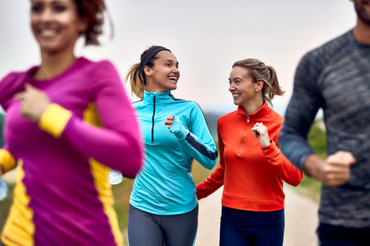 Happy Female Runners Talking While Participating In Marathon.