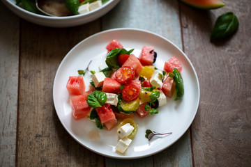 Summer salad with watermelon, tomatoes, feta cheese and basil