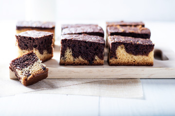 freshly baked brownie on a rustic white wooden background and with some breakfast ingredients