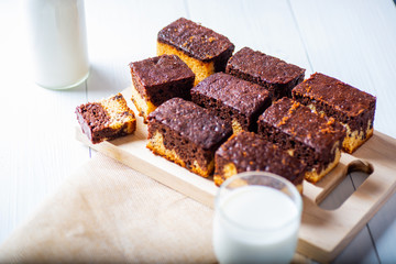 freshly baked brownie on a rustic white wooden background and with some breakfast ingredients