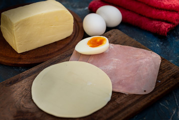 Empanada de jamón y quesos, sus ingredientes,   primer plano sobre una tabla de madera rústica