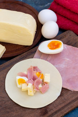 Empanada de jamón y quesos, sus ingredientes,   primer plano sobre una tabla de madera rústica