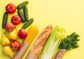 Fresh organic bread, vegetables, greens and fruits, cereals and pasta on a yellow background. Ecological farm food concept. Top view. Flat lay.
