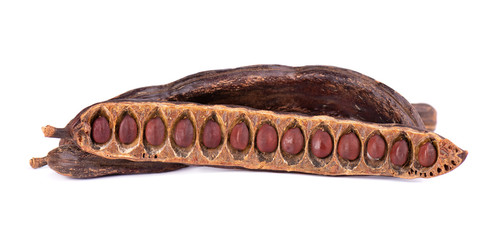 Ripe carob pods and bean isolated on white background.