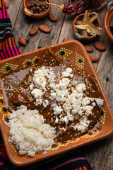 Mexican mole enchiladas with rice on wooden background