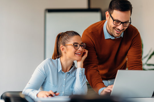 Young developers coding on laptop in the office