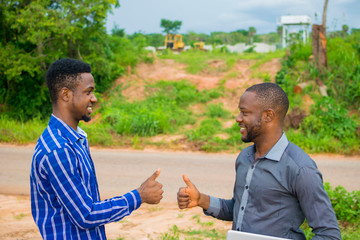 two young african businessmen exchanging handshakes over a done deal.
