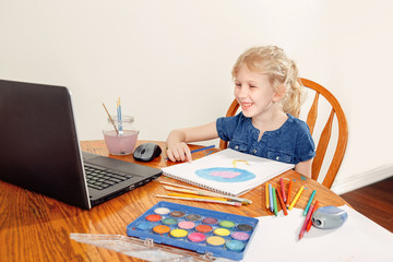 Girl child learning art lesson online on laptop Internet. Virtual drawing painting class on video during self-isolation at home. Distant remote video education. Modern homeschool study new normal.