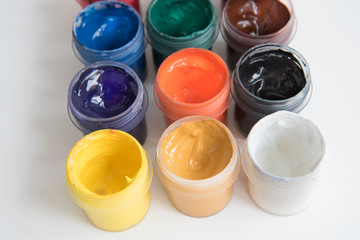 Open cans of paint, top view. Variety, many colors of gouache. Background, texture.