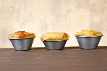 baked pie stuffed with chicken, shrimp, meat on the table, isolated on blurred background. typical Brazilian food empadinha