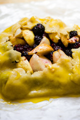 Pear and blackberry galette on a free form and parchment paper