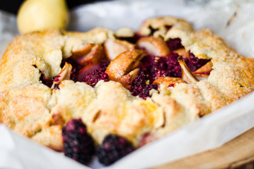 Pear and blackberry galette on a free form and parchment paper