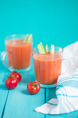 Gazpacho, cold soup on a blue background with fresh ingredients