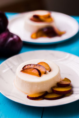 Panna Cotta with fresh plum sauce on a blue background