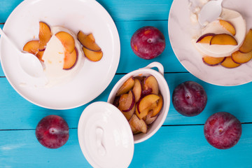 Panna Cotta with fresh plum sauce on a blue background top view