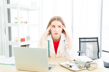 Female beautiful wearing a doctor uniform doing a headache or stressed posture case of treatment.