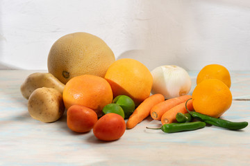 Table with fruits and vegetables on white background