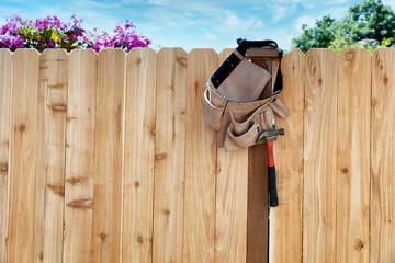 New wooden fence with tool belt and pouch hanging from main post