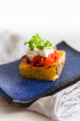 grilled polenta with tomato sauce and cheese and sprouts