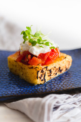 grilled polenta with tomato sauce and cheese and sprouts