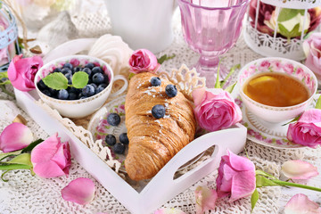 romantic breakfast with croissant and blueberries on white tray