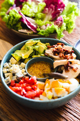 Homemade cobb salad on a rustic wood surface
