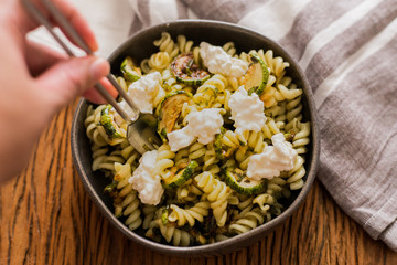 Pasta salad with zucchini and pesto dressing and white cheese