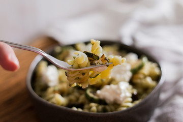 Pasta salad with zucchini and pesto dressing and white cheese