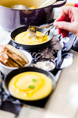 Creamy soup with toast on a white surface