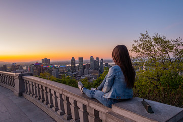 Montreal, Canada - may 2020; young woman admiring the sunrise from the Kondiaronk belvedere, in the Mont-Royal park - obrazy, fototapety, plakaty