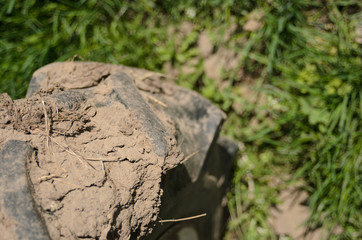 Tractor wheel with lumps of dirt after agricultural work. Selective focus with shallow depth of field.