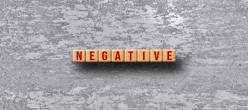 wooden cubes with the word NEGATIVE on concrete background