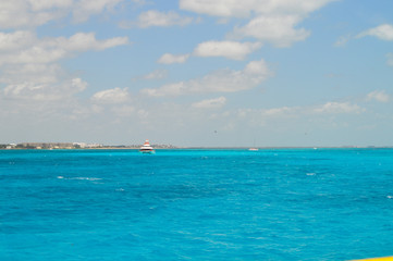 Fototapeta na wymiar hermosa vista del mar azul con barco de fondo