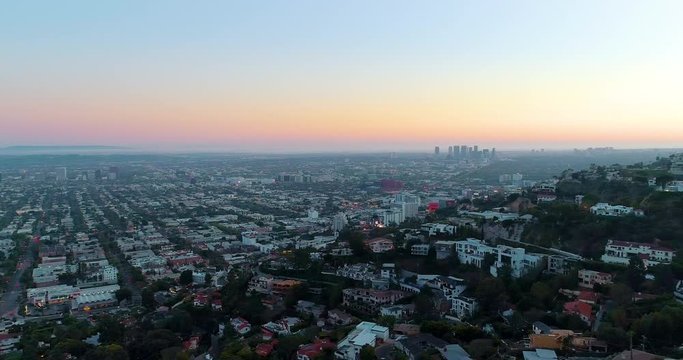 Aerial, pan drone shot overlooking the The Hollywood Hills, West Hollywood, Beverly Hills and all the way to Century City Twin Towers and Culver City, in Los Angeles, colorful dusk, in California, USA