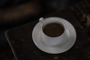 
A cup of coffee resting on a wooden table