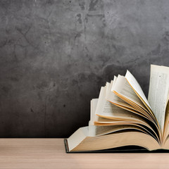 The book is open, lying on the table, sheets fanned out on a black background.