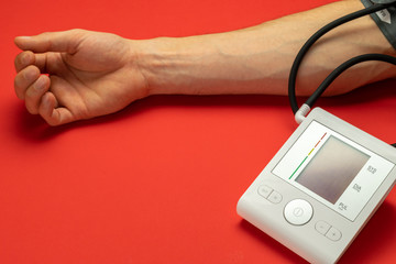 Pressure meter. Patient test hypertension from medical sphygmomanometer. Health monitor for check doctor blood pressure isolated on red background. Man hand cardio control.