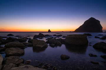 Fototapeta na wymiar Pacific ocean at sunset, stones and rocks. Landscape, beautiful sunset sky