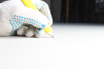 building yellow pencil in hand .construction glove