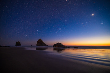 Fototapeta na wymiar Night landscape on the Pacific Ocean, with a landscape but a starry sky. Cannon Beach