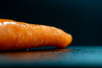 Racimo de zanahorias frescas sobre fondo negro