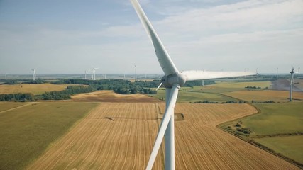 Close up view of spinning blades on wind energy tower. Windmill turning in breeze generates electricity. Sustainable earth friendly renewable resources that reduce pollution.