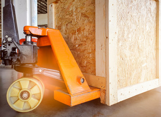 Hand pallet truck with wooden crate. Cargo shipment export, warehouse shipping goods.