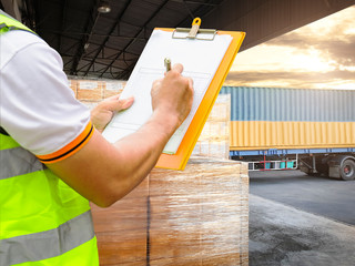 Freight industry warehouse shipment transport. Worker courier holding clipboard inspecting checklist load cargo into a truck.