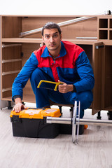 Young handsome male carpenter working indoors