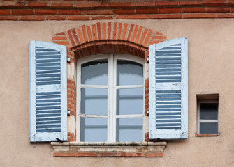 Fototapeta na wymiar Window with shutters on the wall of the old house