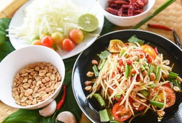 Thai food top view - papaya salad spicy with yardlong bean herbs and spices ingredients chilli tomato peanut garlic served on table