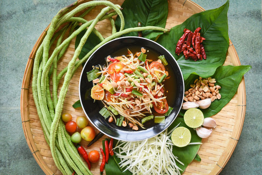Thai food top view - papaya salad spicy with yardlong bean herbs and spices ingredients chilli tomato peanut garlic served on table